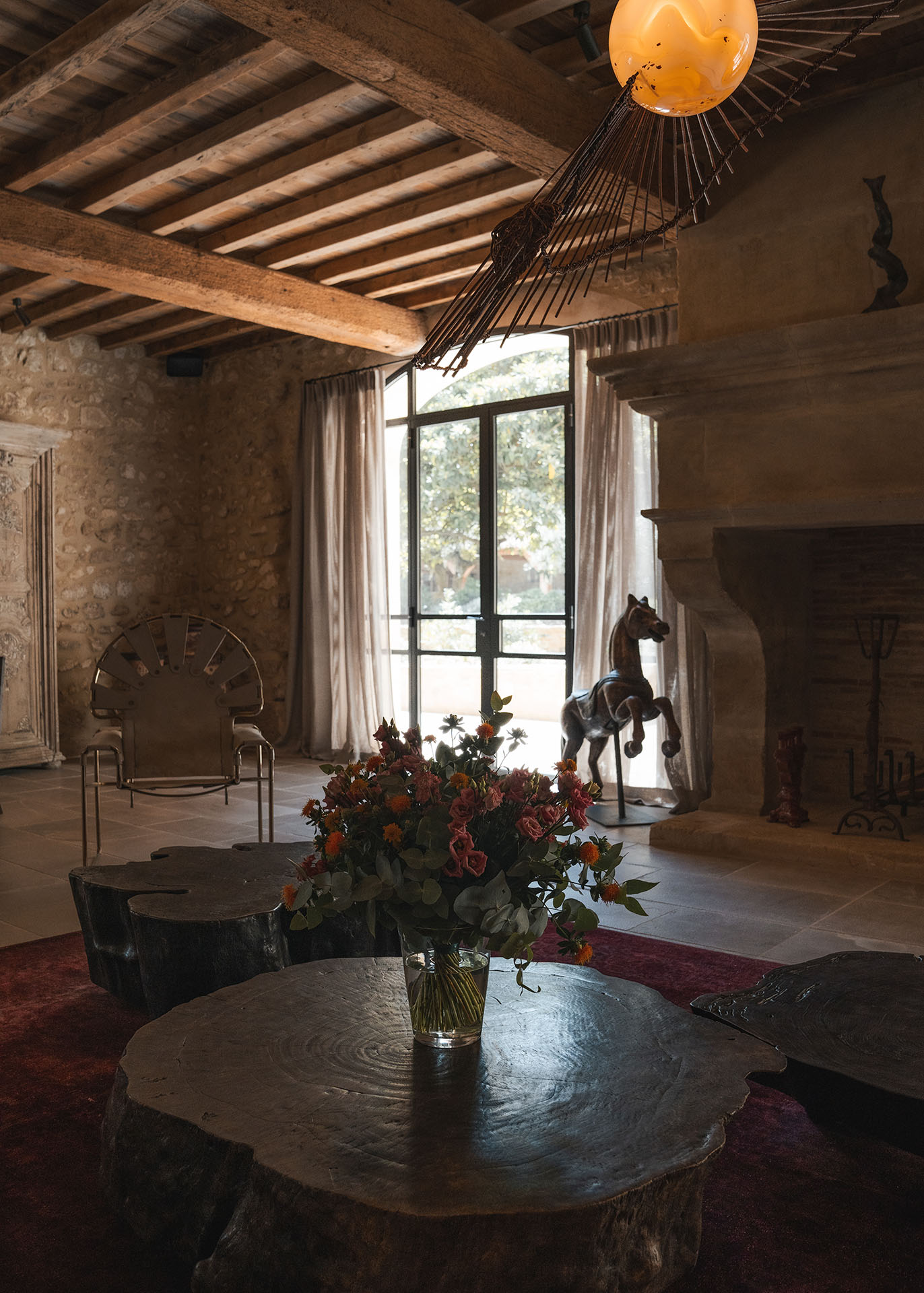 Bright living room at Le Mas de Castillone featuring a stone fireplace and comfortable sofas