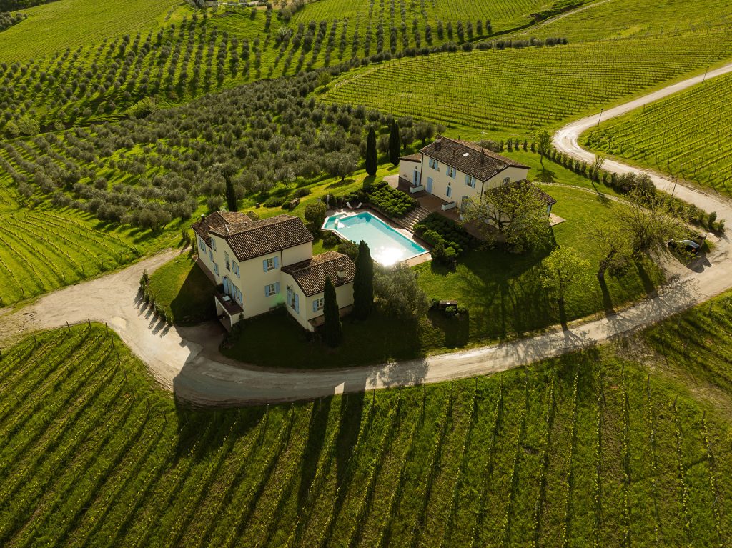 Aerial view of Borgo Condé Wine Resort nestled among vineyards and olive groves.